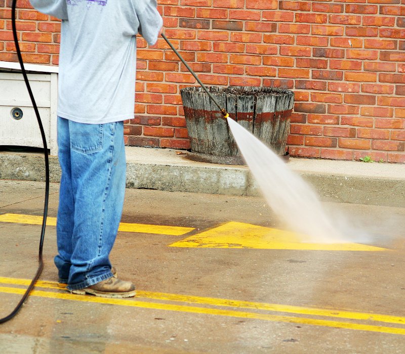 High-pressure commercial concrete cleaning in progress on a sidewalk