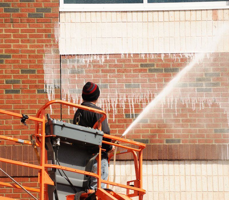 High-rise commercial pressure washing on a brick building